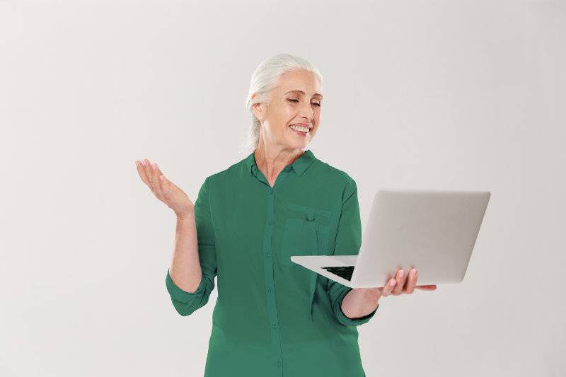 Funny mature woman using laptop computer isolated over white